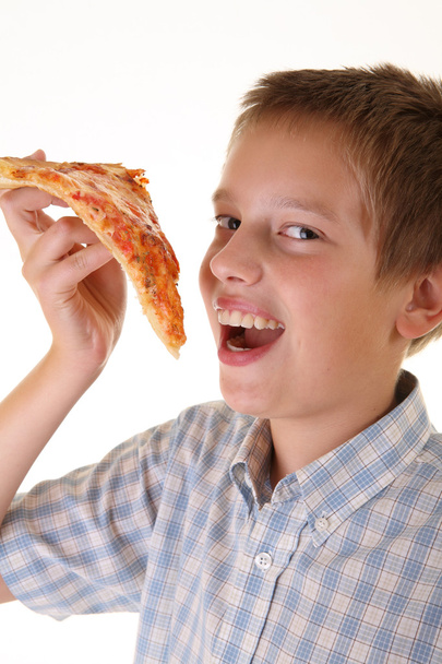 Young boy eating pizza - Фото, изображение