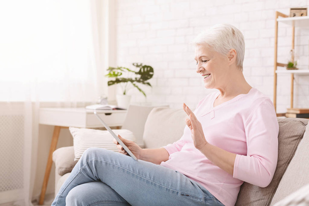 Щаслива старша жінка розмовляє з сім'єю за допомогою цифрового планшета
 - Фото, зображення