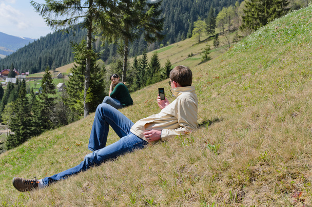 Man using his mobile in the mountains - Photo, Image