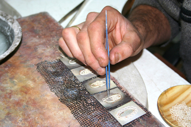 Рабочие руки производят серебряные украшения
 - Фото, изображение