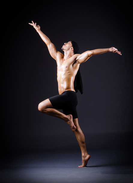 Dancer dancing in the dark studio - Фото, зображення