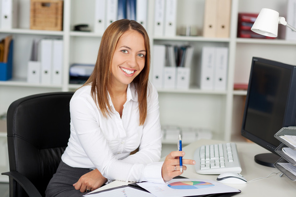Businesswoman Holding Pen At Office Desk - Foto, imagen