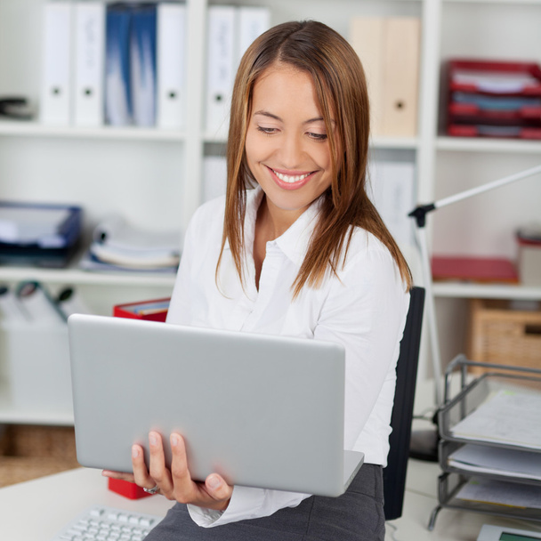 Businesswoman Holding Laptop In Office - Φωτογραφία, εικόνα