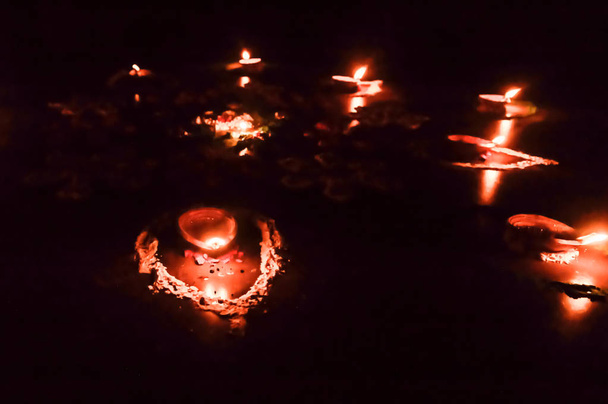 Група прикрашених Diya- Oil Lamp засвітилася в святковому сезоні Diwali на чорному тлі. Концепція видалення темряви. - Фото, зображення