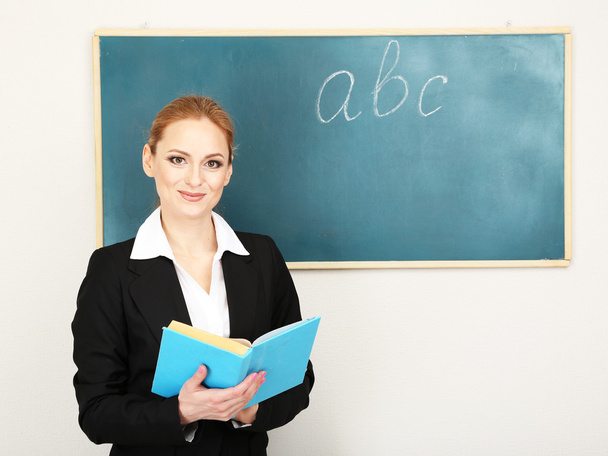 Portrait of teacher woman near chalkboard in classroom - Photo, Image