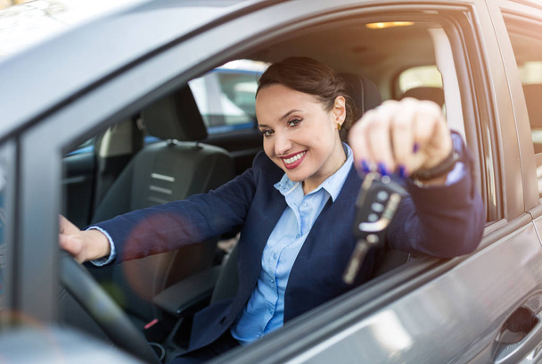 Young businesswoman sitting in car holding car keys - Фото, зображення