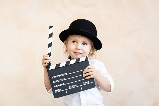 Child with clapper board playing at home. - Zdjęcie, obraz