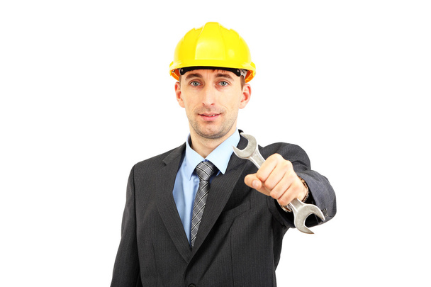 Young businessman in helmet with wrench isolated on whit - Fotó, kép