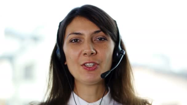 4K. ładna kobieta operator w słuchawkach odpowiedzieć klientowi. Portret - Materiał filmowy, wideo