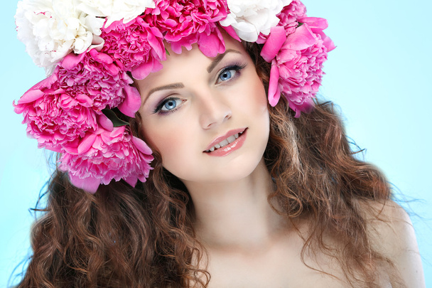 beautiful young girl with pink flowers on a blue background - Фото, зображення