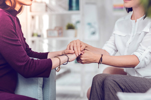 Close-up photo of a psychologist holding hand of female patient - Zdjęcie, obraz