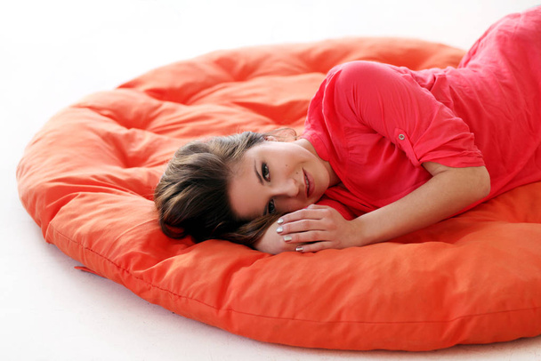 Sinnliche junge Frau träumt auf orangefarbener Decke - Foto, Bild