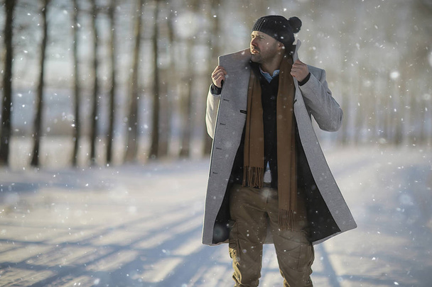 модний чоловік в пальто / зимовому стилі, йде на тлі зимового пейзажу, сніжної погоди, теплого одягу
 - Фото, зображення
