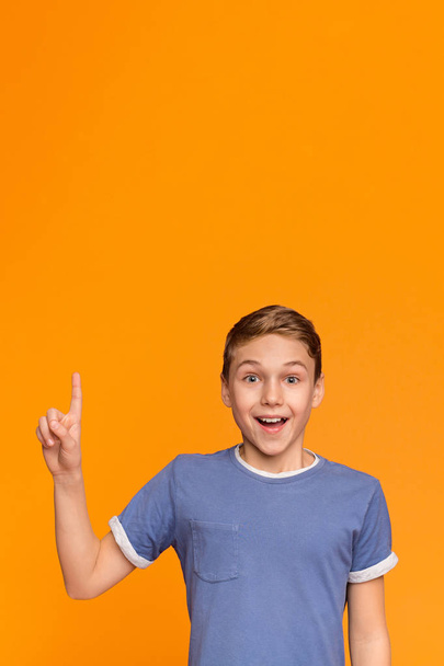 Ενθουσιασμένος έφηβο αγόρι έχουν μεγάλη ιδέα, δείχνοντας το δάχτυλό σας επάνω - Φωτογραφία, εικόνα