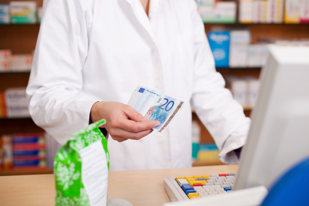 Paying For Medicine Using Cash At Pharmacy - 写真・画像