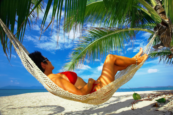 weergave van mooie vrouw loungen in hangmat in tropische omgeving - Foto, afbeelding