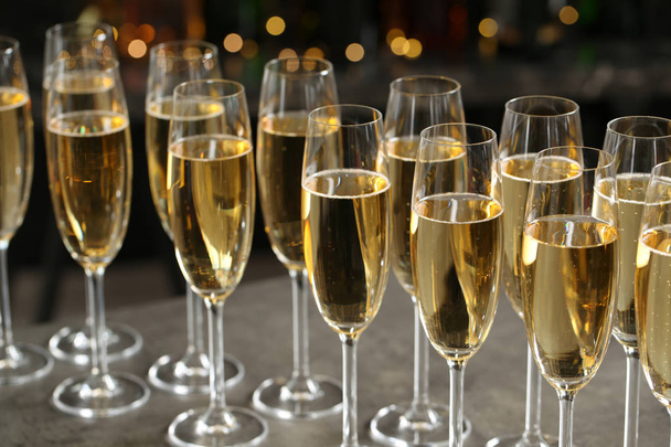 Glasses of champagne on table against blurred background - Photo, image