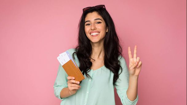 Ready for trip. Girl holding tickets and showing peace gesture - Photo, Image