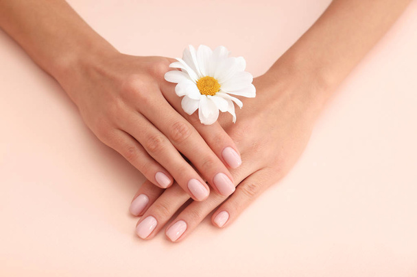 Closeup view of woman with flower on color background. Spa treatment - Foto, Imagen