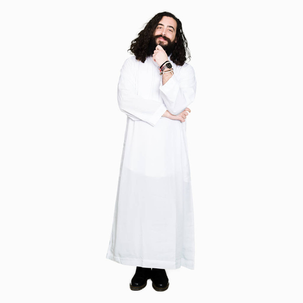 Man wearing Jesus Christ costume looking confident at the camera with smile with crossed arms and hand raised on chin. Thinking positive. - Photo, Image
