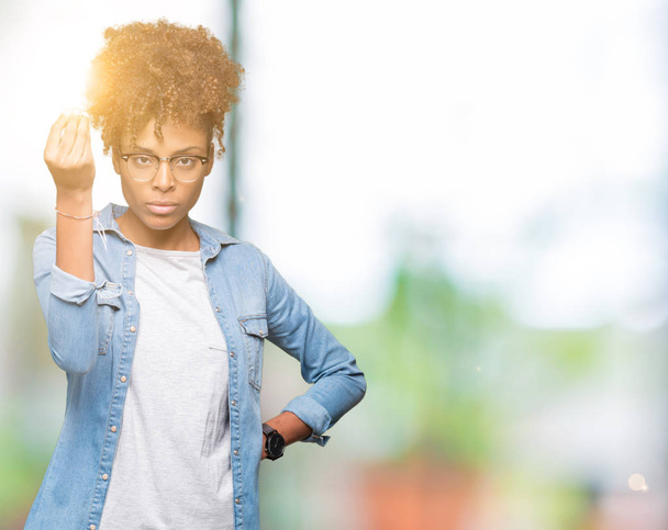 Όμορφη νεαρή αφρικανική αμερικανική γυναίκα φοράει γυαλιά πέρα από το απομονωμένο υπόβαθρο κάνει ιταλική χειρονομία με το χέρι και τα δάχτυλα αυτοπεποίθηση έκφραση - Φωτογραφία, εικόνα