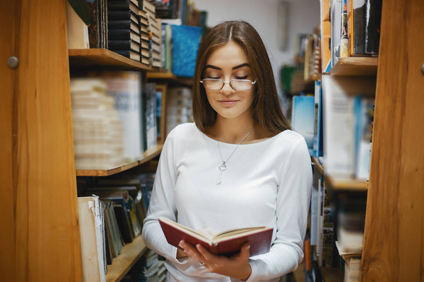 girl in the library - Фото, изображение