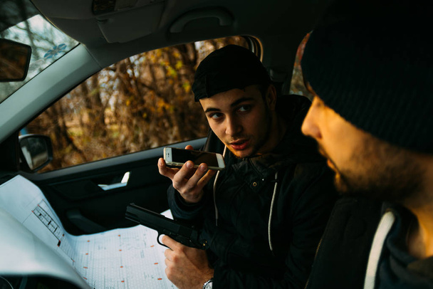 Two armed bandits sitting in a car planning their next robbery,  - Foto, Imagen