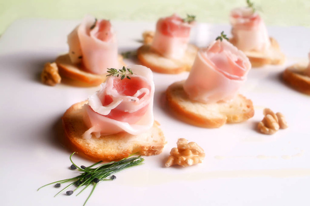 Italian food recipes, spiced with herbs Colonnata lard rolls on toasted bread slices. - Photo, Image
