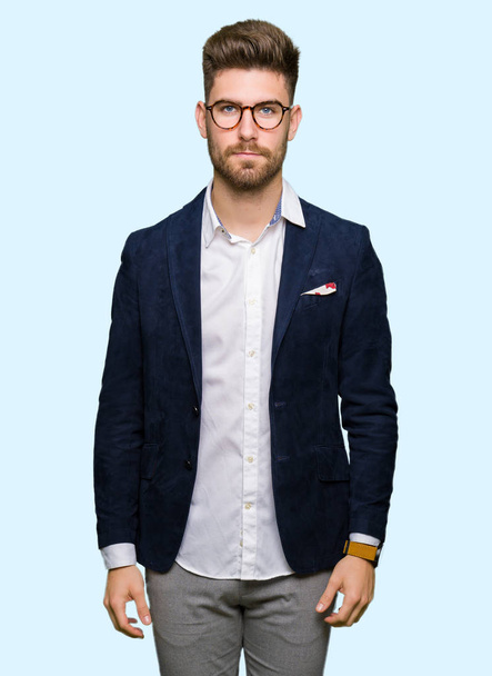 Young handsome business man wearing glasses with serious expression on face. Simple and natural looking at the camera. - Foto, Imagen