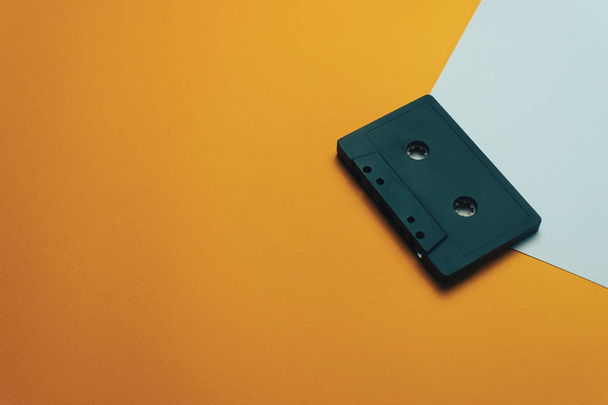 Чёрная классическая магнитная кассета на оранжевом фоне
. - Фото, изображение