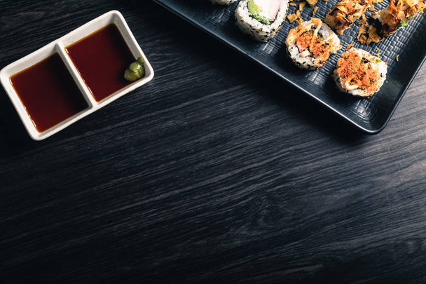 Sushi rolls with soy sauce on dark background. Space text - Valokuva, kuva