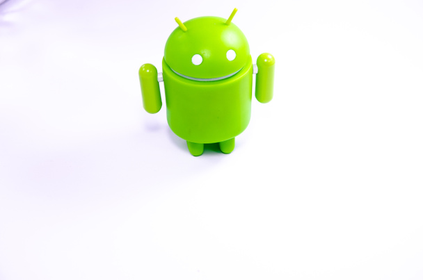 April 2019. Los Angeles,USA. Green plastic Android figure on a white background and with a smartphone. Figure, logo Android, Google - Photo, Image