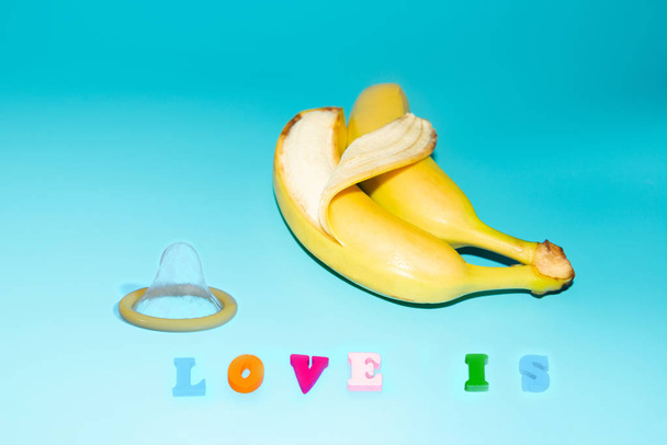 Óvszerek és két banán együtt, a fogamzásgátlók fogalma és az azonos neműek közötti házasság nemi betegségeinek megelőzése. - Fotó, kép
