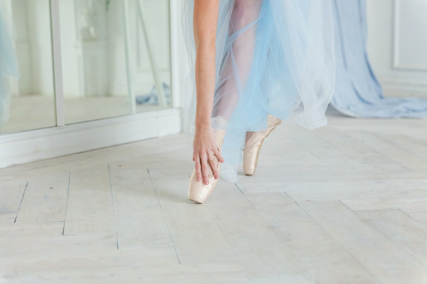 Ballerine mains met pointes chaussures sur la jambe en classe de danse
 - Photo, image