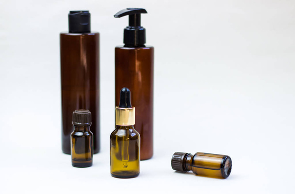 Dark cosmetic bottles on a light background. Copy space Beauty salon blogger, salon therapy, minimalist concept. - Фото, зображення