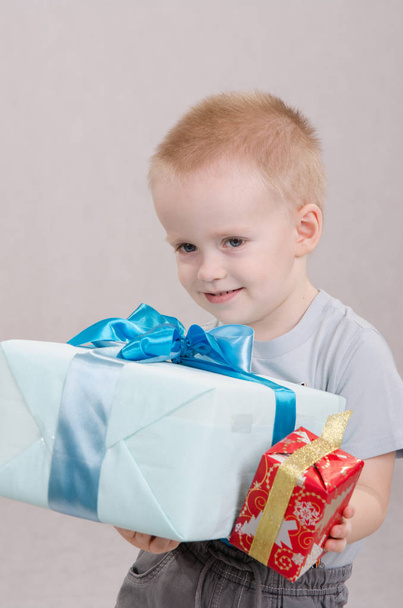 Portrait of a five year old boy with a gift in hands - Photo, Image