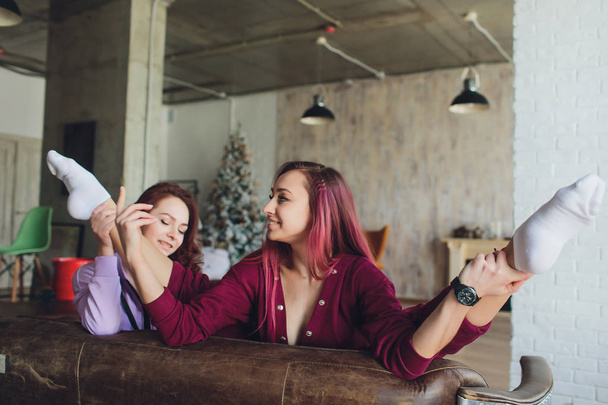 LGBT Cute young girls smiling and flirting on sofa at home. - Valokuva, kuva