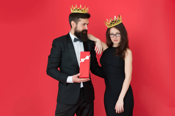 Royal gift. Queen of his heart. Man bearded king in tuxedo golden crown giving gift box to woman elegant dress. Royal family. Couple in love royal family. Elite society. King and queen formal event - Photo, image