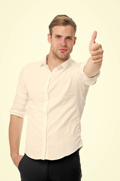 Excellent quality. Guy shows thumb up. Man calm face posing confidently ready to help white background. Guy with bristle glad to help you in shop. Man shop consultant looks confident and hospitable - Valokuva, kuva
