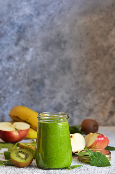 Green smoothie with banana, kiwi, apple and spinach on a concret - Фото, зображення