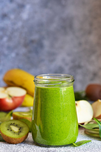 Green smoothie with banana, kiwi, apple and spinach on a concret - Valokuva, kuva