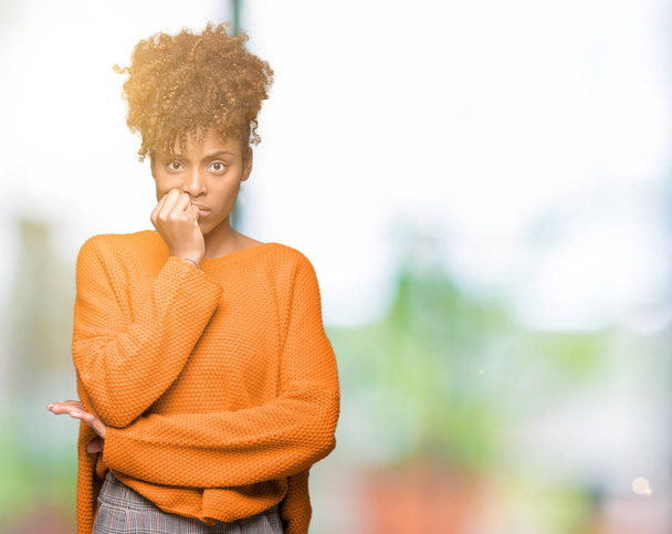 Mooie jonge Afro-Amerikaanse vrouw op geïsoleerde achtergrond op zoek gestresst en nerveus met handen op mond nagels te bijten. Angst probleem. - Foto, afbeelding