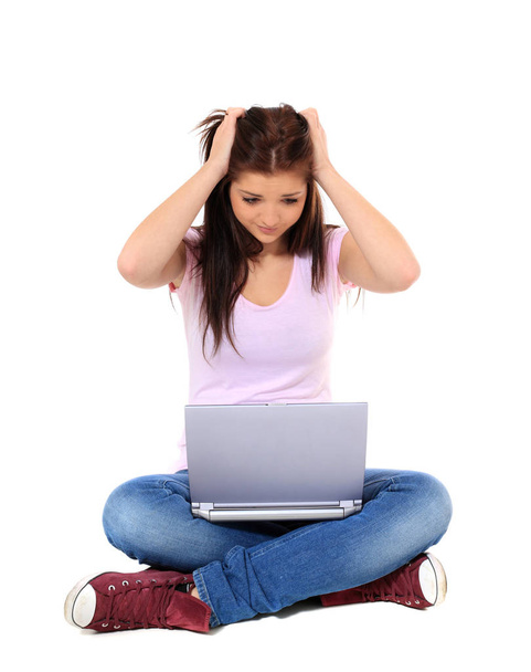 Attractive teenage girl got a problem with her laptop. All on white background. - Fotografie, Obrázek