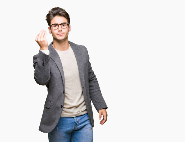 Młody biznes człowiek noszenie okularów na białym tle robi włoski gest dłoni i palców pewnie wyrażenie - Zdjęcie, obraz