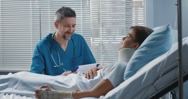 病院でティーンエイジャー患者を訪問する男性医師 - 映像、動画