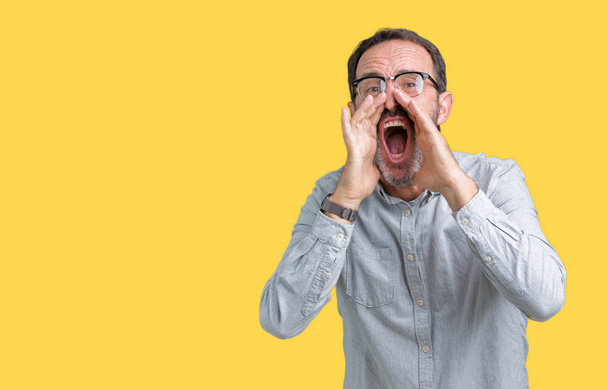 Komea keski-ikä tyylikäs vanhempi mies silmälasien yli eristetty tausta huutaa vihainen ääneen kädet suun yli
 - Valokuva, kuva