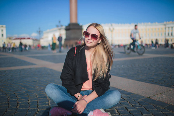 Beautiful woman sitting with monument in the background. - 写真・画像