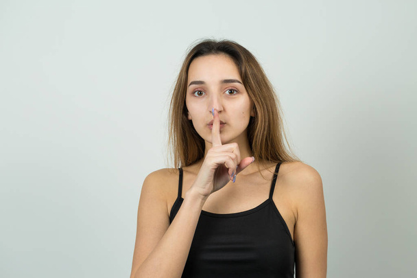 Young caucasian girl with silence sign on white background  - Photo, Image