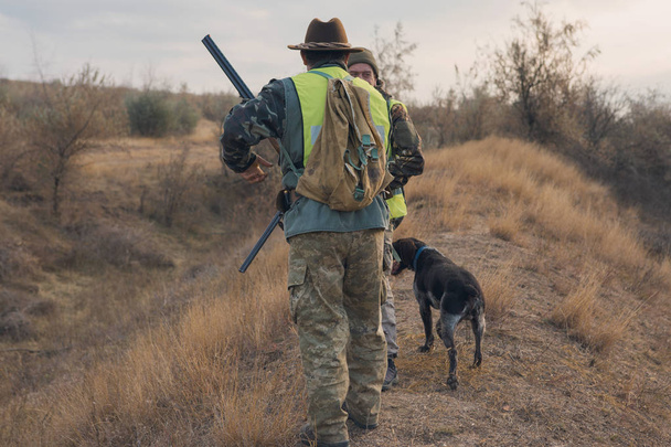 Cazadores masculinos con caza de escopetas al aire libre - Foto, Imagen