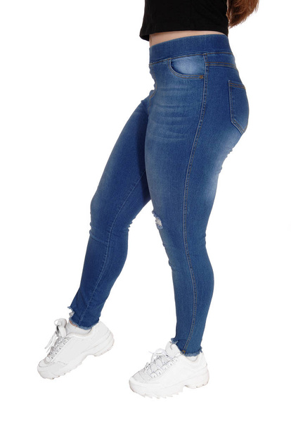 O fundo e as pernas de uma jovem em jeans
 - Foto, Imagem